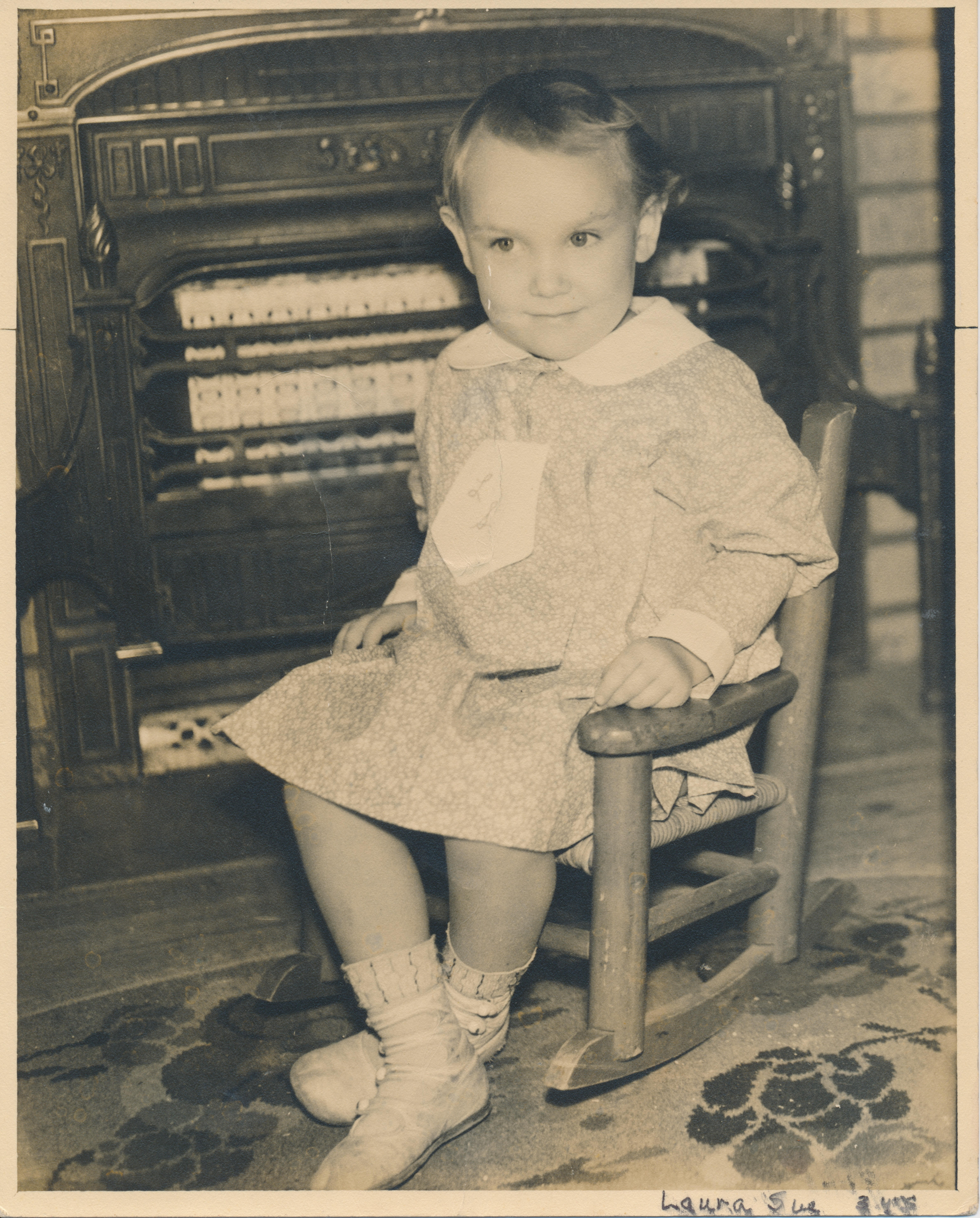 Laura Sue as a small child in a rocking chair