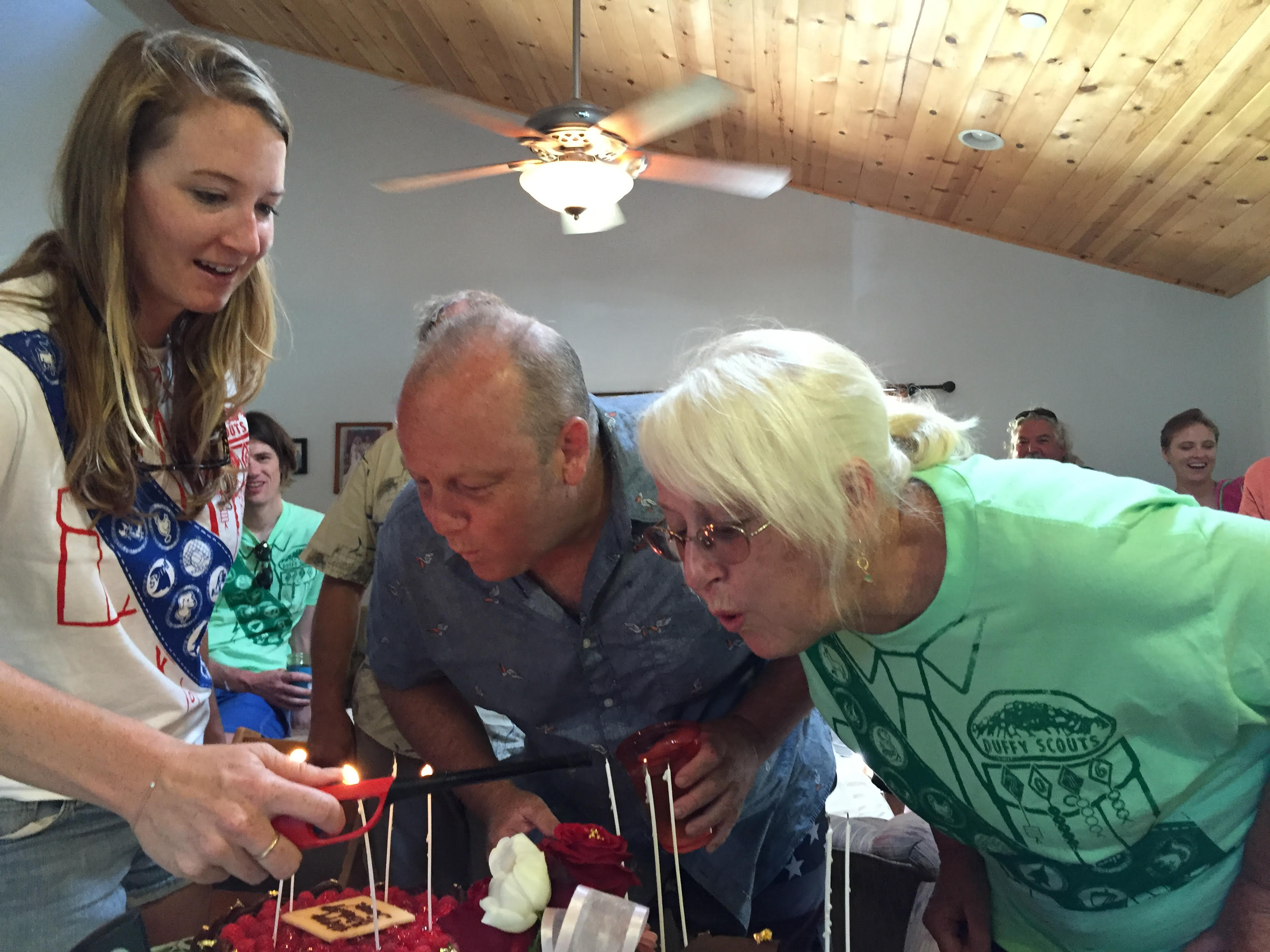Sue blowing out birthday candles with family